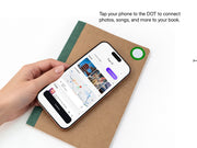 Tapping a phone to the DOT tag on a Spruce notebook cover to connect photos, songs, and locations