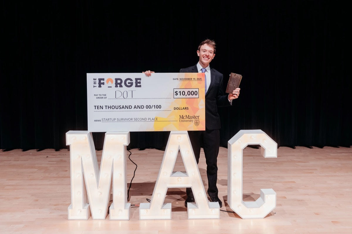 On stage at The Forge Startup Survivor with the $10,000 second-place cheque and a DOT prototype
